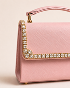 Close-up of crystal embellishment detail on blush pink top handle bag flap, featuring square and round cut crystals in gold setting, The House of Shine Bijou Edit