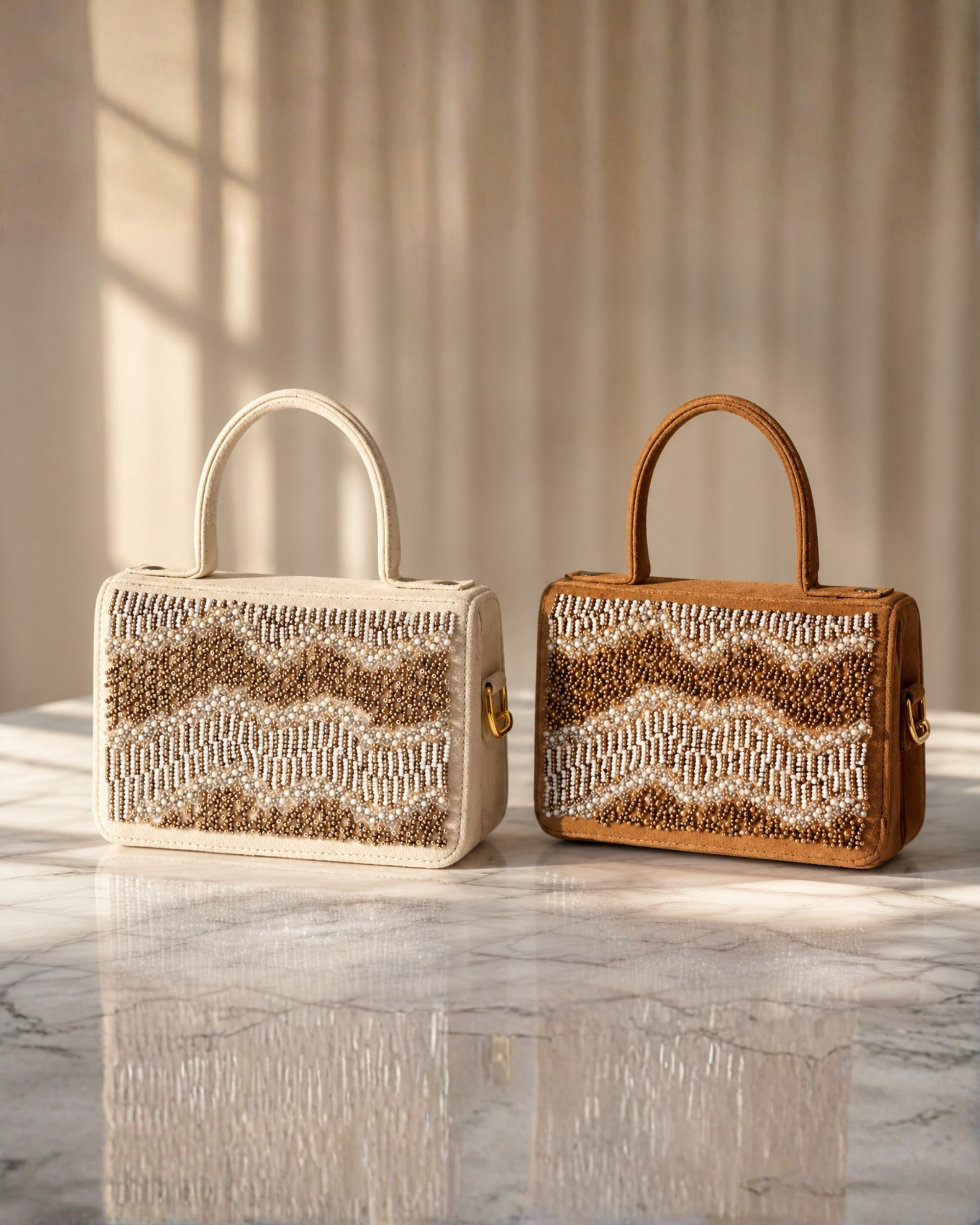 Boho hand-beaded satchel by House of Shine in both colourways — Ivory and Caramel butter suede with rose gold and silver chevron beading, side by side on white marble surface in warm window light