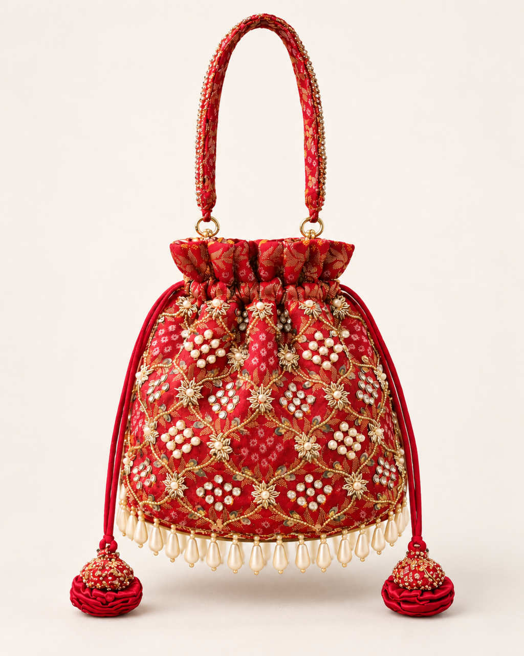 Studio front view of the red Gulnaar Bandhej potli with gold embroidery, pearl detailing and matching tassels.