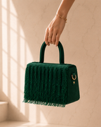 Woman's hand holding green Cascade Satchel with gold jewelry accents