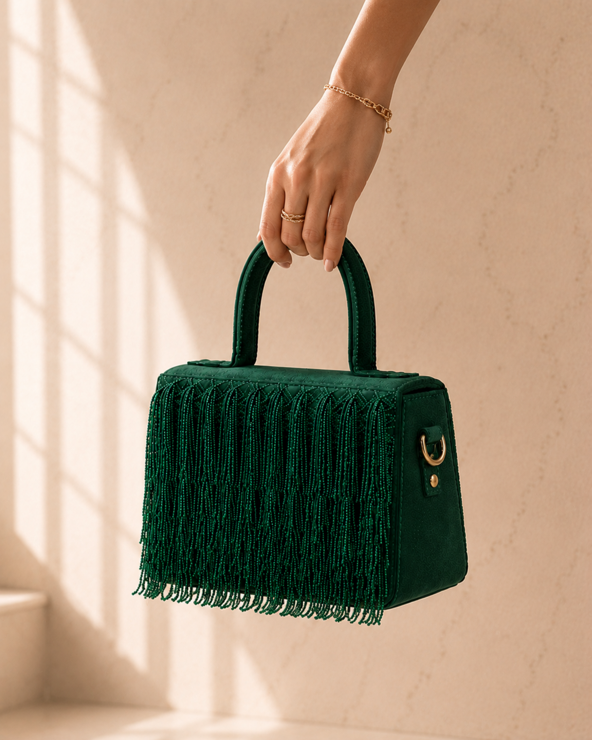 Woman's hand holding green Cascade Satchel with gold jewelry accents