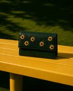 Front view of the Girasole green mini shoulder bag with hand-embroidered yellow flowers and crocodile-textured base.