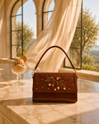 Luxury handbag India — The Nocciola shoulder bag styled beneath stone archway with flowing curtains