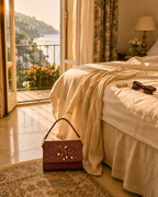 Luxury embroidered satchel — The Nocciola styled on bedroom floor with sea-view balcony