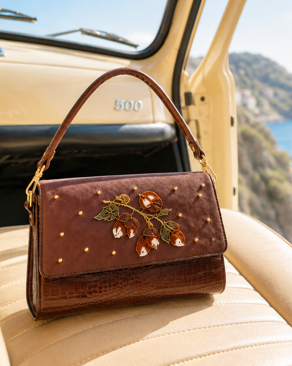 Luxury handbag India — The Nocciola close-up on vintage car interior, coastal backdrop