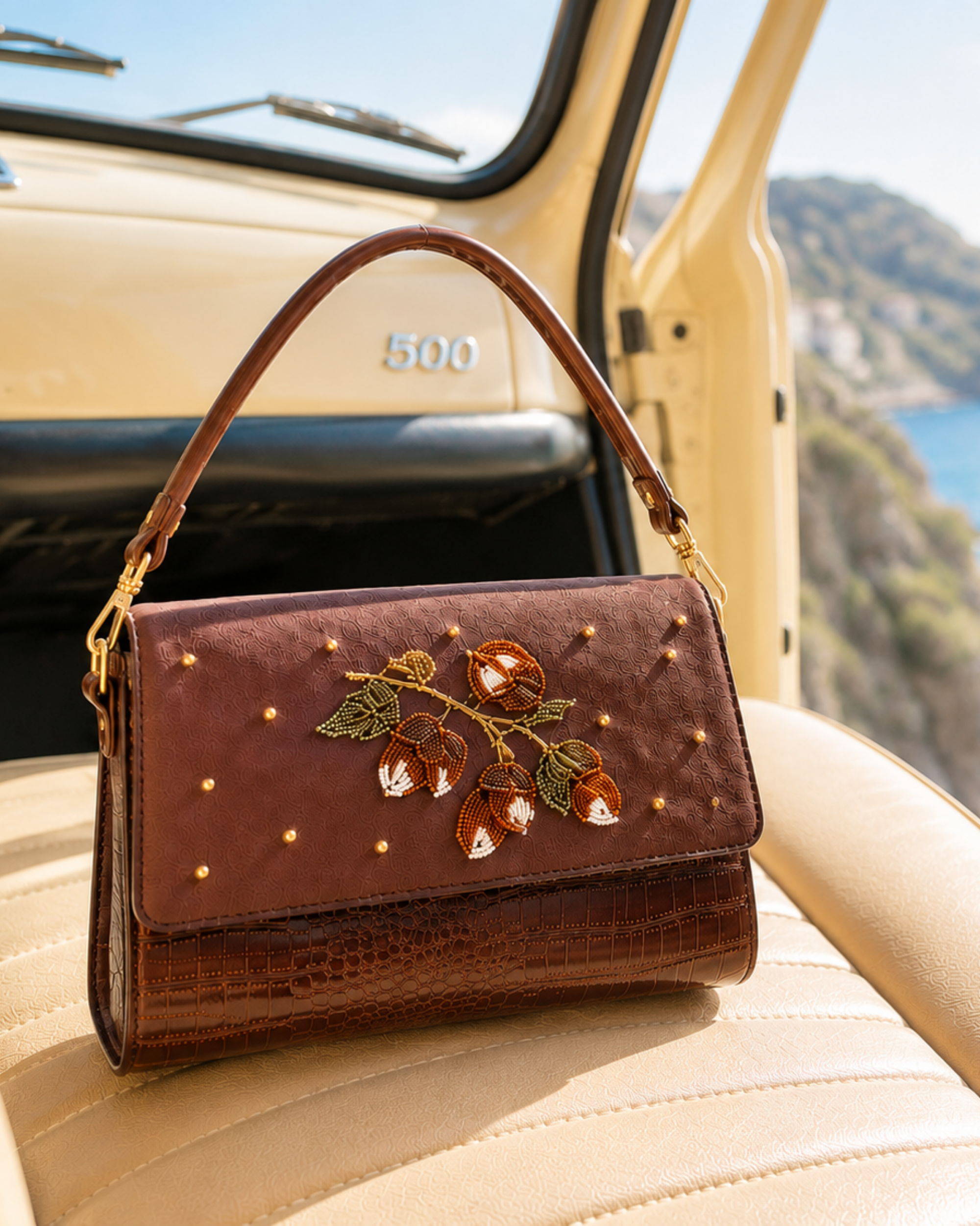 Luxury handbag India — The Nocciola close-up on vintage car interior, coastal backdrop