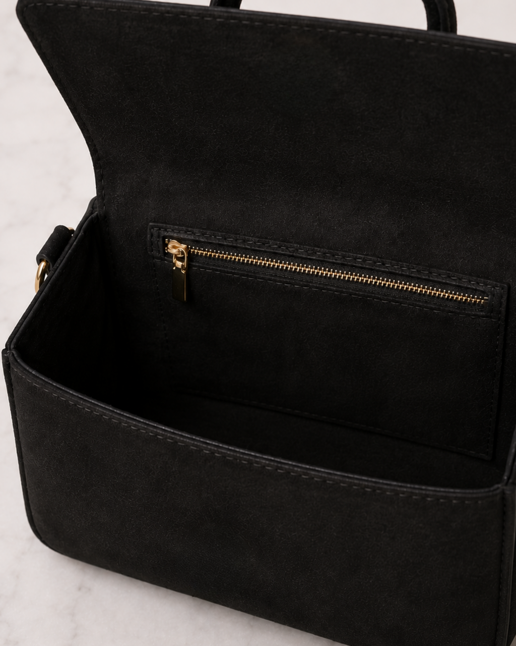 Interior view of The House of Shine Prisma black satchel showing spacious main compartment and gold zip pocket in black suede lining