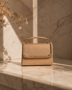 Liquid Gold crystal-embellished mini top-handle bag by House of Shine, front view on sunlit marble with dried golden botanicals, gold-polished hardware, saffiano exterior, Bijou Edit.