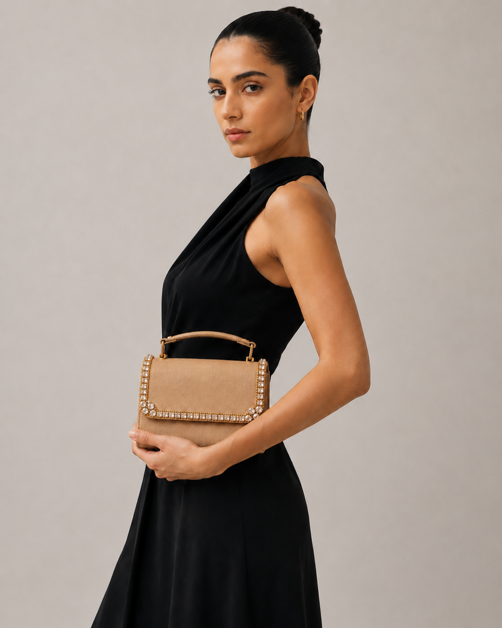 Model in black halter dress holding Liquid Gold crystal-embellished mini top-handle bag by House of Shine, gold-polished hardware, saffiano exterior, Bijou Edit.