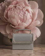 Close-up video of silver Moonlit crystal-embellished mini bag by House of Shine, camera zooming in and out to show hand-set crystal trim, saffiano texture, and gold-polished hardware, Bijou Edit.