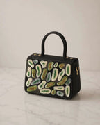 The House of Shine Prisma hand-embroidered black satchel — close-up detail of green and ivory sequin and bead embroidery