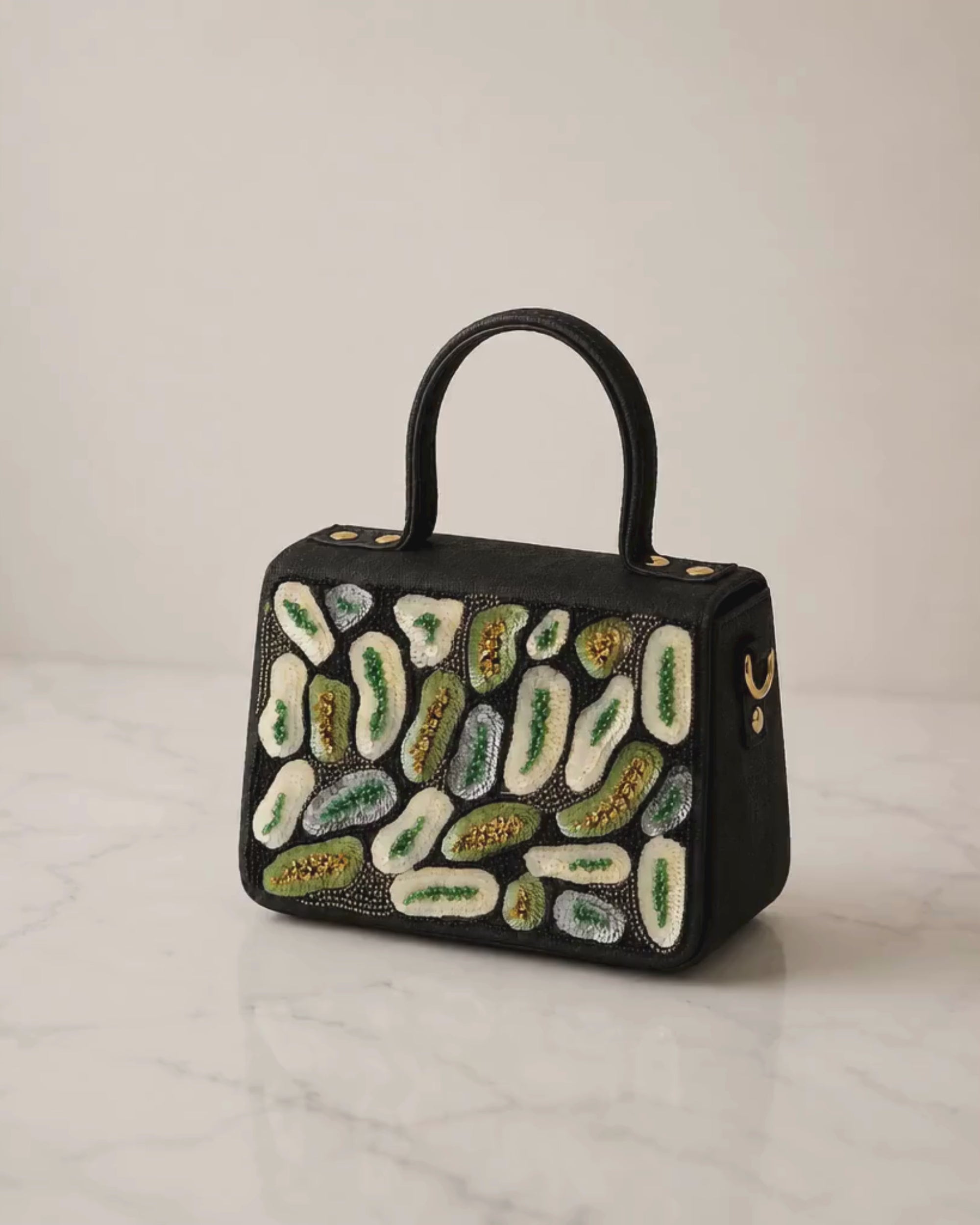 The House of Shine Prisma hand-embroidered black satchel — close-up detail of green and ivory sequin and bead embroidery